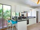 Modern kitchen with white cabinets and stainless steel appliances