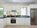 Modern kitchen with white cabinetry and stainless steel appliances