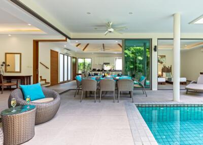 Open living area with dining setup and pool view