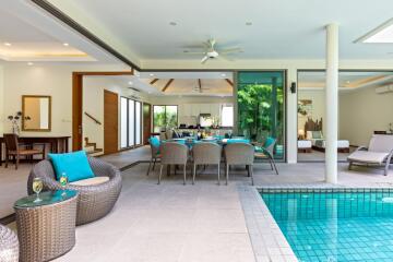 Open living area with dining setup and pool view