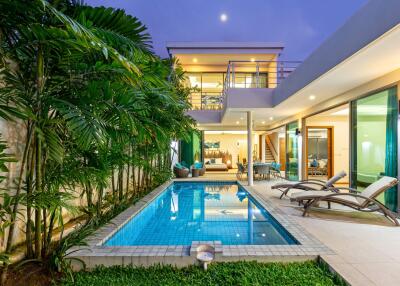 Modern house with swimming pool and garden at dusk