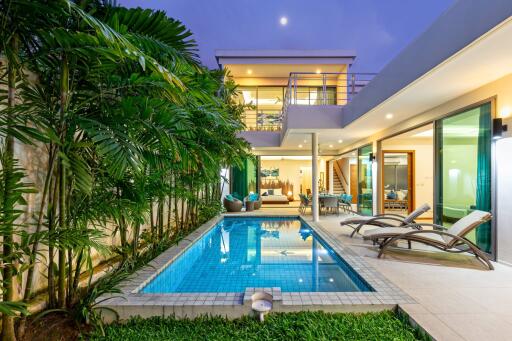 Modern house with swimming pool and garden at dusk