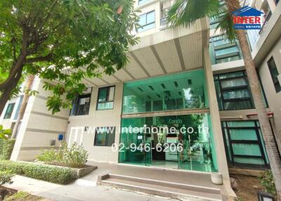 Modern apartment building entrance with lush greenery