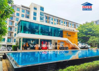 Exterior view of a residential complex with a large swimming pool