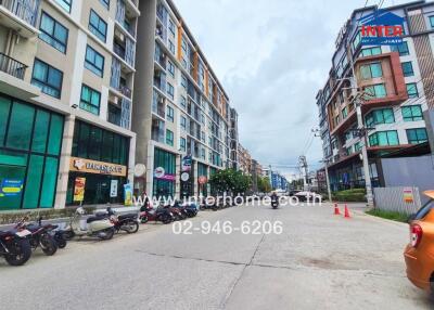 Residential building exterior with nearby street and parked scooters