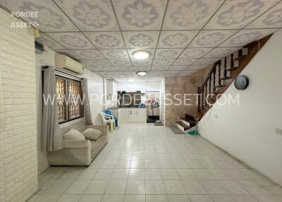 Living room with sofa, tiled floor, and staircase