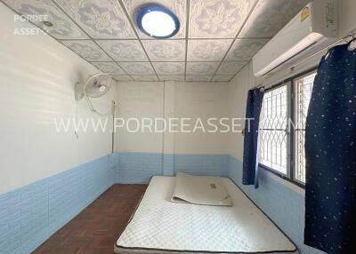 Bedroom with a mattress, ceiling fan, air conditioning, and decorative ceiling tiles