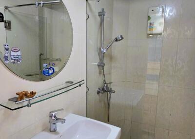 Modern bathroom with a glass shower enclosure and a round mirror