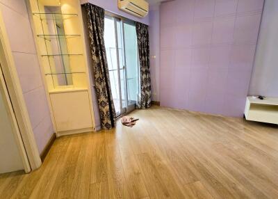 Living room with wooden flooring and access to a balcony