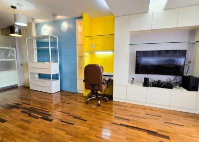 Modern living area with work station, TV, and hardwood floors