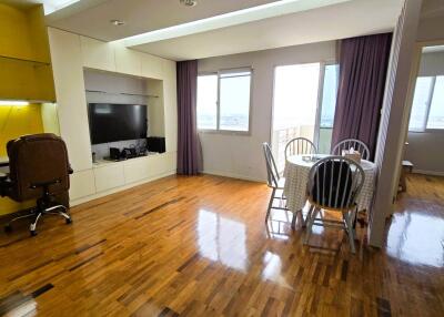 A spacious living area with a small dining table and an office nook