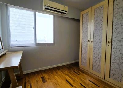 Bedroom with wooden floor, air conditioning, and wardrobe