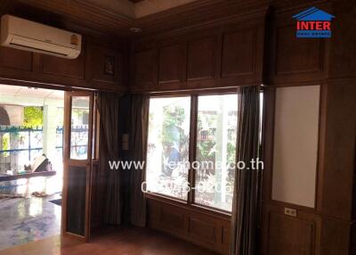 Living room with large window and wooden paneling