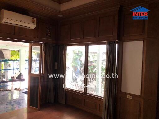 Living room with large window and wooden paneling