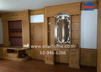 Living room with wooden cabinetry and decorative mirror