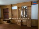 Living room with wooden cabinetry and decorative mirror