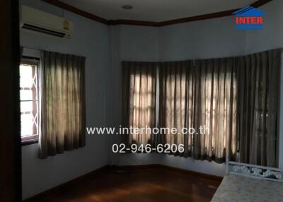 Bedroom with multiple windows, air conditioning, and wooden floor