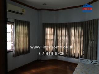 Bedroom with multiple windows, air conditioning, and wooden floor