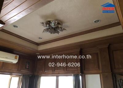 Living room ceiling with wooden paneling and chandelier