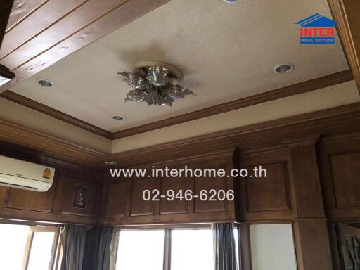 Living room ceiling with wooden paneling and chandelier