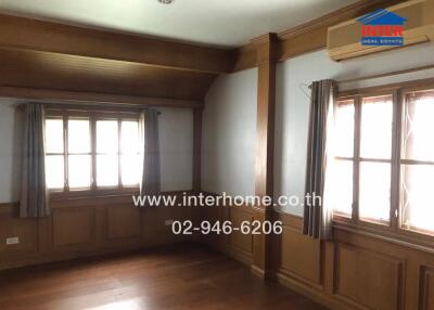 Living room with wooden flooring, windows, air conditioning, and curtains