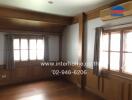 Living room with wooden flooring, windows, air conditioning, and curtains