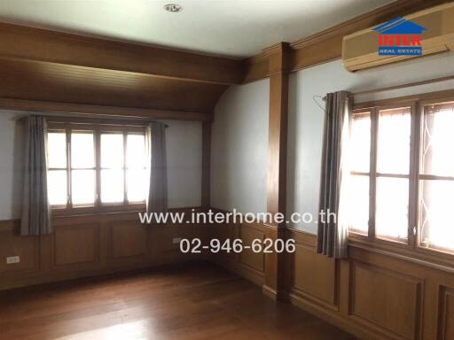 Living room with wooden flooring, windows, air conditioning, and curtains