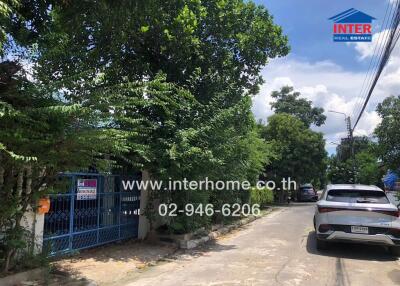 Street view with cars and a gated property