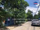 Street view with cars and a gated property