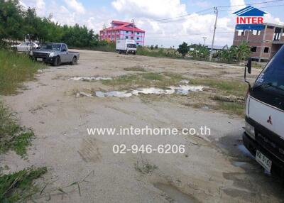 Outdoor parking area with some vehicles and a building under construction in the background