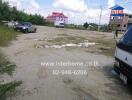 Outdoor parking area with some vehicles and a building under construction in the background