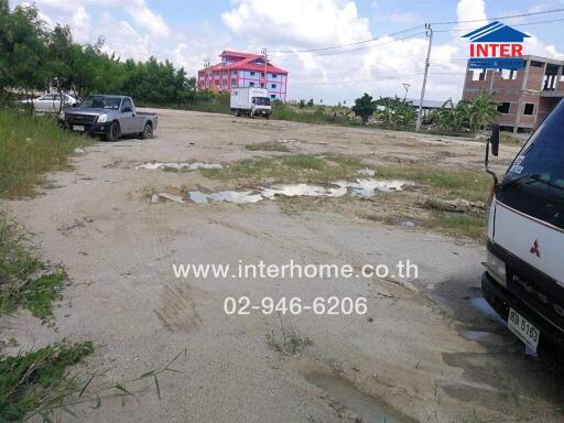 Outdoor parking area with some vehicles and a building under construction in the background