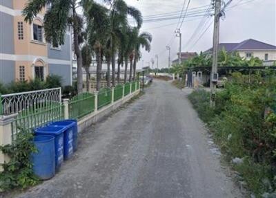 Street view in front of a property with palm trees and residential buildings