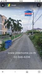 Street view in front of a property with palm trees and residential buildings