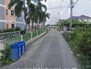 Street view in front of a property with palm trees and residential buildings