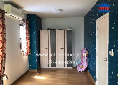 Bedroom with wooden floor, blue and white themed decor featuring wardrobes, air conditioning, and window with curtains