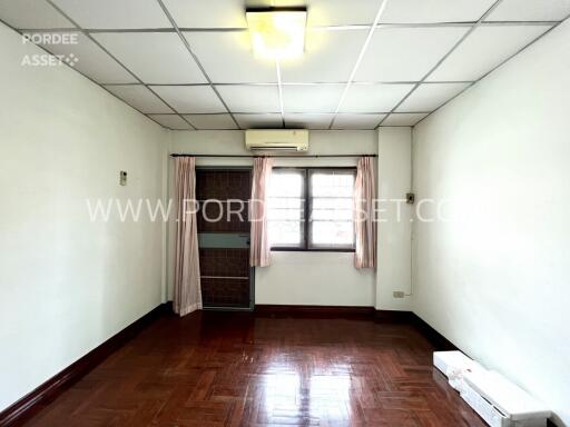 A vacant bedroom with a window and air conditioning unit