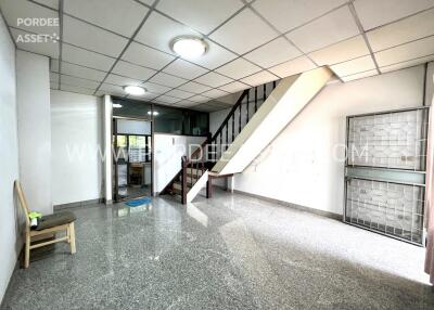 Spacious living area with tiled flooring and staircase