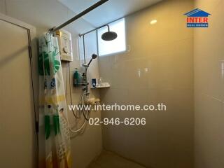 Modern bathroom shower area with water heater and a small window