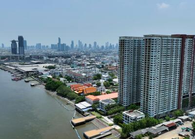 High-rise building next to a river with cityscape in the background