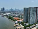 High-rise building next to a river with cityscape in the background