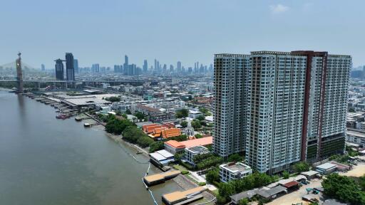 High-rise building next to a river with cityscape in the background