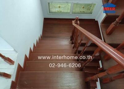 Wooden staircase with railing and stained glass windows