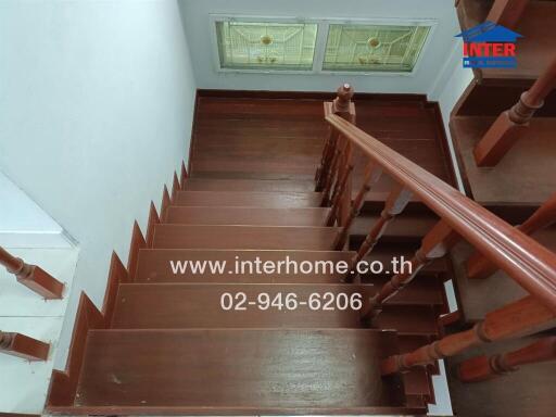 Wooden staircase with railing and stained glass windows