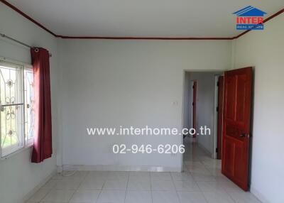 Bedroom with a window, red curtains, and a wooden door