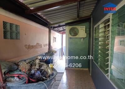 Exterior walkway with visible air conditioning unit and storage items