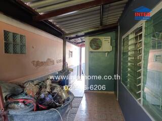 Exterior walkway with visible air conditioning unit and storage items