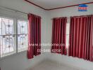 Bedroom with two windows and maroon curtains