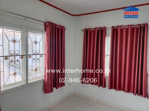 Bedroom with two windows and maroon curtains