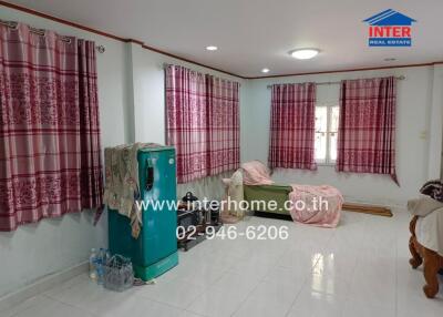 Living room with patterned curtains, seating area, and freezer